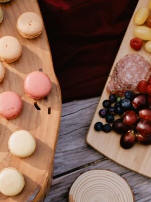 A top view of a charcuterie board with fresh fruits and macarons, perfect for gatherings.