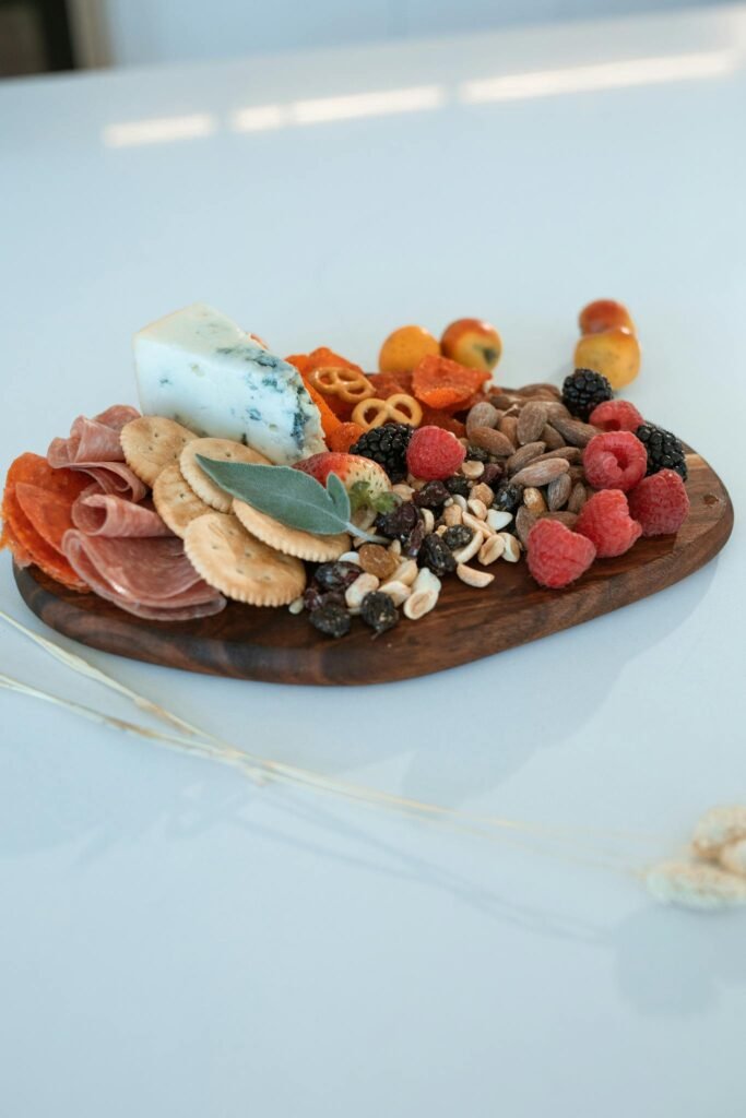 Elegant charcuterie board featuring cheese, fruits, nuts, and cured meats on a wooden platter.