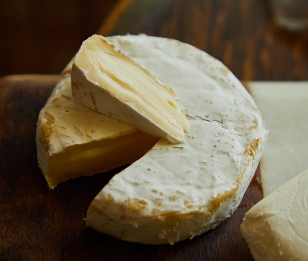 Delicious Camembert cheese wheel and slice showing creamy texture.